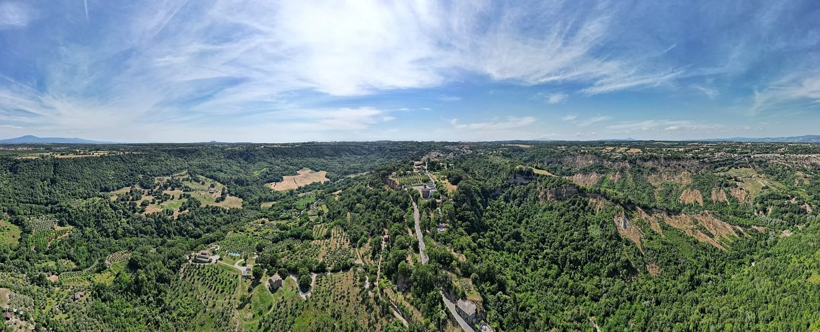 Veduta aerea di Bagnoregio e della campagna circostante tra boschi, uliveti e le pareti dei calanchi